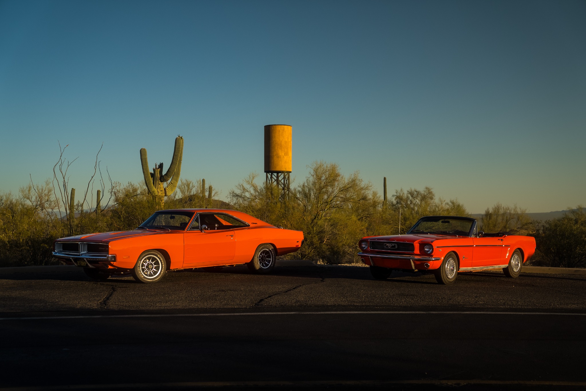 Orange Dodge Charger and red Mustang Convertible photographed together in the Tucson desert