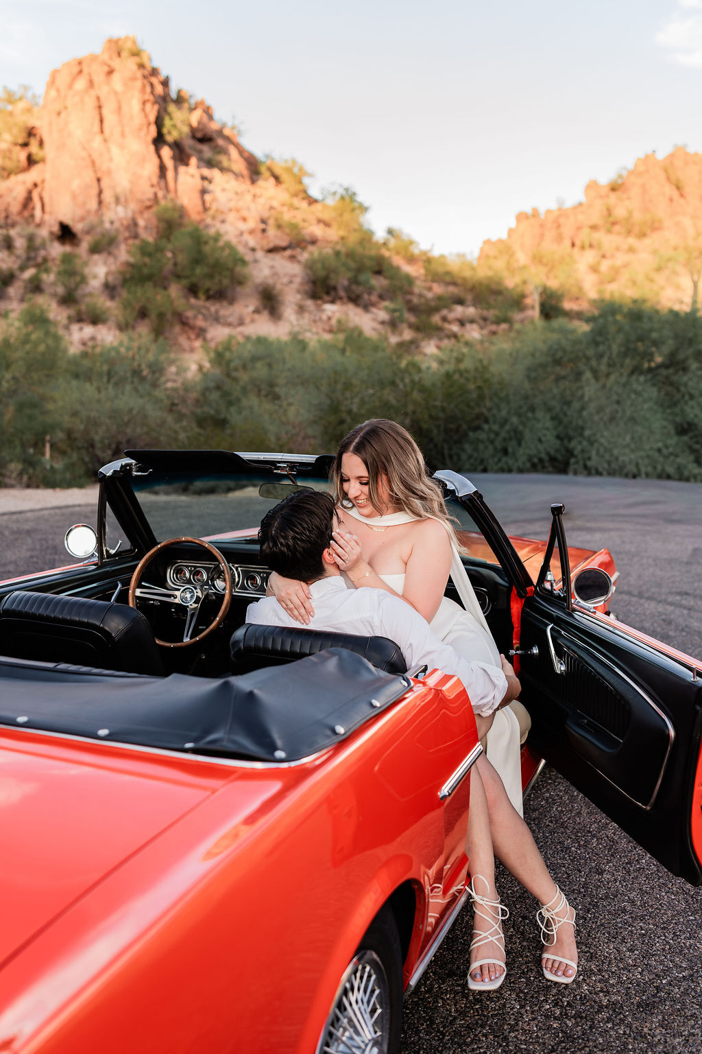 Couple sharing a playful moment in the red Mustang Convertible